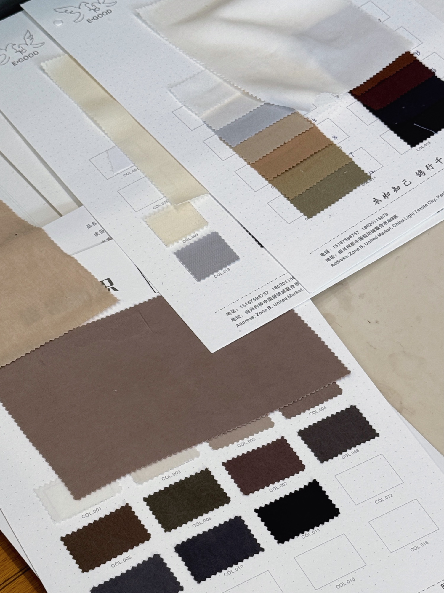 Neutral fabric swatch cards spread across a work table